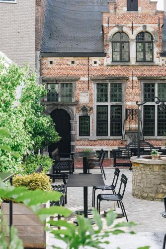 a group of tables and chairs in front of a building at Hotel FRANQ in Antwerp