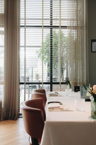 a room with a table and chairs and a large window at Hotel FRANQ in Antwerp