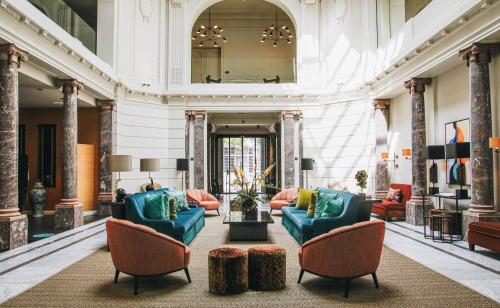 a lobby with couches and chairs and a mirror at Hotel FRANQ in Antwerp