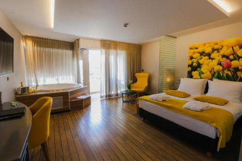 ein Schlafzimmer mit einem großen Bett und einem Gemälde an der Wand in der Unterkunft Wellness Hotel Villa Magdalena in Krapinske Toplice