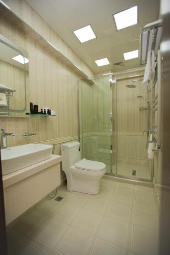 a bathroom with a toilet and a sink and a shower at Baku Hotel Ganja in Ganja