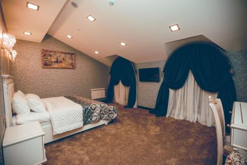 a bedroom with a bed and blue drapes at Baku Hotel Ganja in Ganja