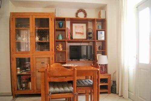 a dining room with a table and a tv at the bougainvillea house in Symi