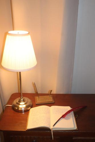 an open book on a desk with a lamp and a lampocument at carré coco in Sainte-Luce