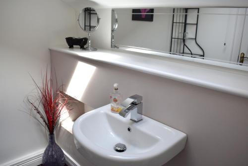 a bathroom with a white sink and a mirror at The Meadows B&B in Moville