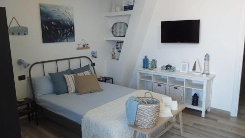a bedroom with a bed and a tv on the wall at La Casetta di Laura in Cefalù
