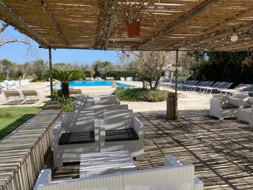 a group of white lounge chairs under a pavilion at Agriturismo Tenuta Sant'Antonio in Cerfignano