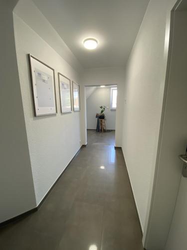 an empty hallway with white walls and a long hallway with at Apartment Meine in Meine