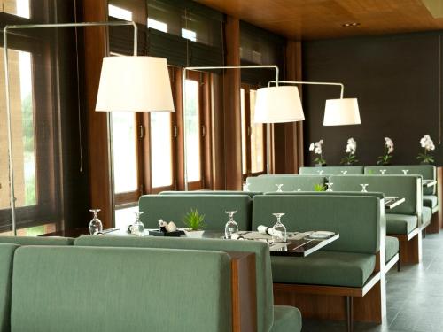 a dining room with green chairs and tables and lights at Emerald Palace Hotel in Nay Pyi Taw