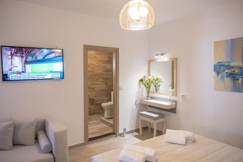 Serenity Luxe Suites في بارغا: غرفة معيشة مع أريكة ومغسلة