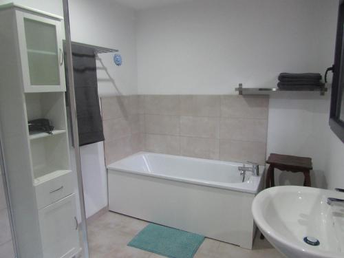 une salle de bain avec une baignoire et un lavabo dans l'établissement La linotiere, à Osly-Courtil