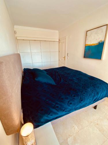 a bedroom with a bed with a blue blanket at LUXURY 3 BEDROOM HOUSE AT LA QUINTA GOLF COURSE OCEAN and MOUNTAIN VIEW in Benahavís