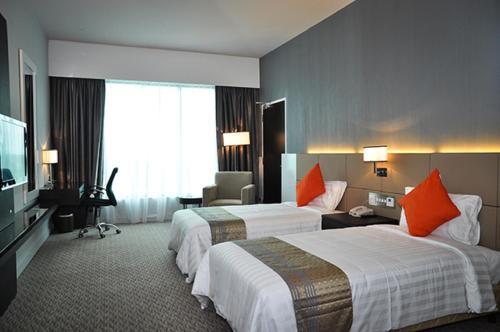a hotel room with two beds and a television at Raia Hotel & Convention Centre Alor Setar in Alor Setar