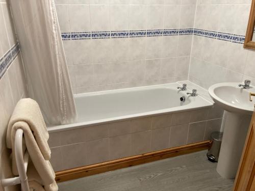 The Waie Inn في Copplestone: حمام مع حوض استحمام ومغسلة