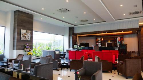 a waiting room with brown chairs and red furniture at Raia Hotel & Convention Centre Alor Setar in Alor Setar