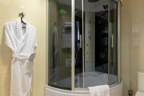 a bathroom with a shower with a white towel on a rack at U Istoka Hotel in Irkutsk