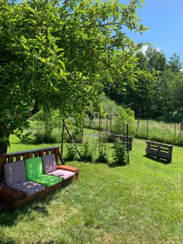 a couch sitting in the grass under a tree at Chambres d'hôtes "La Bouill'hôte" in Langensoultzbach