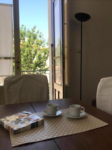 a table with two coffee cups and a book on it at appartamento Vintage in Torrenova