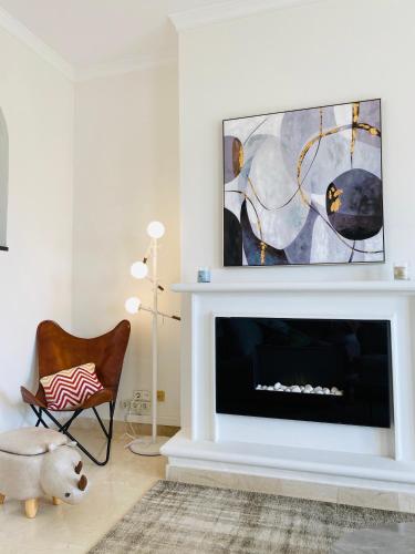 a living room with a fireplace with a tv above it at LUXURY 3 BEDROOM HOUSE AT LA QUINTA GOLF COURSE OCEAN and MOUNTAIN VIEW in Benahavís