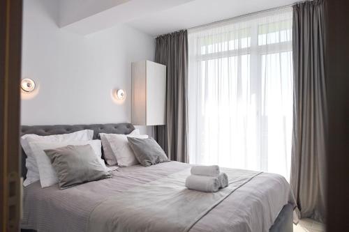 1 dormitorio blanco con 1 cama grande y ventana en Aba Luxury Studio Spa n Pool Beach resort en Mamaia-Sat