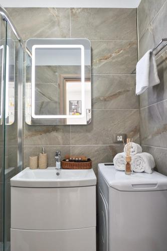 a bathroom with a sink and a mirror at Aba Luxury Studio Spa n Pool Beach resort in Mamaia Sat/Năvodari