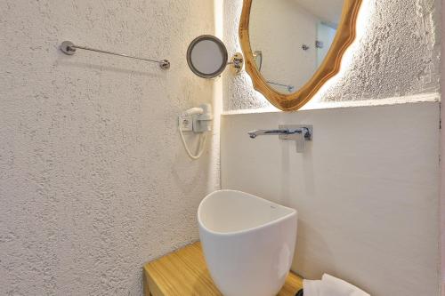 a bathroom with a toilet and a mirror at Atalante Hotel in Kas