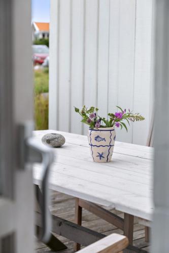 a vase with flowers sitting on a table at Villa Tjurpannan Grebbestad in Grebbestad