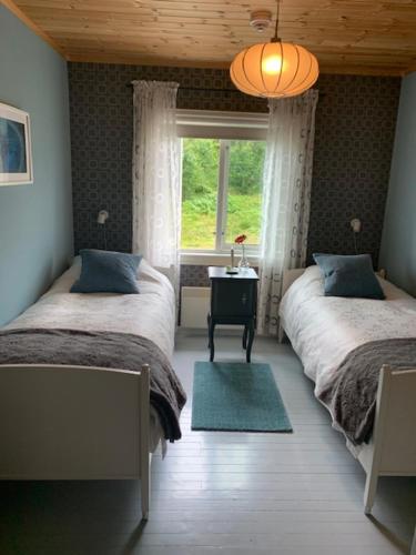 a bedroom with two beds and a window in it at Nordbø Pensjonat in Hjartdal