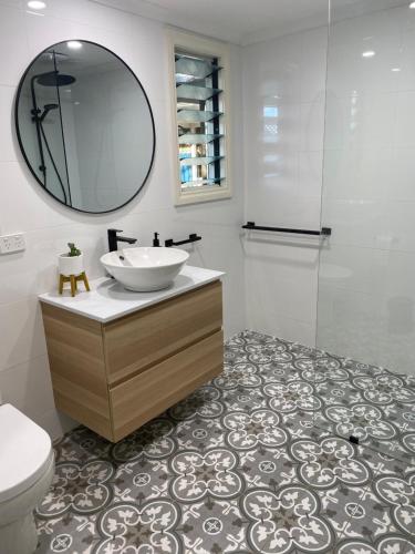 a bathroom with a sink and a mirror and a toilet at Goolwa Mariner’s Cottage - Free Wifi and Pet Friendly - Centrally located in Historic Region in Goolwa