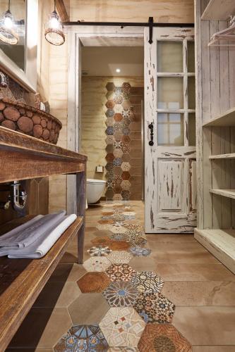 a bathroom with a toilet and a door with a tile floor at Alakapi Hotel & Villas in Alaçatı