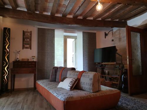 a living room with a couch and a tv at Bed & Breakfast SENTIERO 54 in Cantiano
