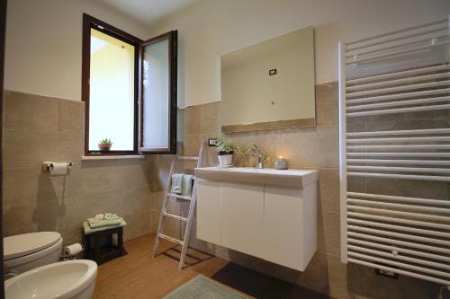 a bathroom with a sink and a toilet and a window at Il RosAle a Celle Ligure in Celle Ligure