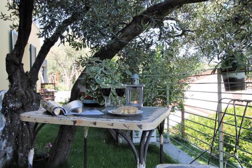 a table under a tree with a plate of food on it at Il RosAle a Celle Ligure in Celle Ligure