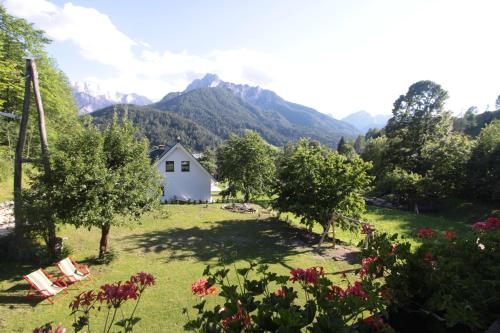 a house in a field with mountains in the background at Apartments Ela in Rateče