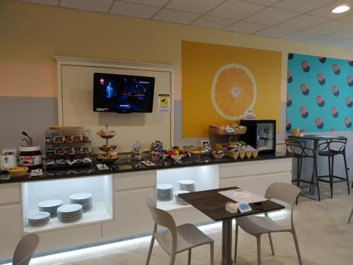 a waiting room with a table and a tv at Hotel Motel 2 in Castel San Giovanni