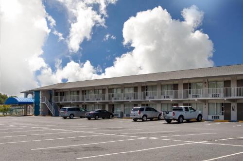 a building with cars parked in a parking lot at Days Inn by Wyndham Apopka/Orlando in Orlando