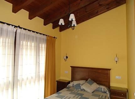 1 dormitorio con cama y ventana en Vivienda vacacional La Poza la Braña, en Llanes