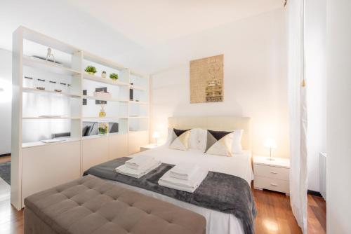 a white bedroom with a large bed with white shelves at Milan Royal Suites - Centro in Milan