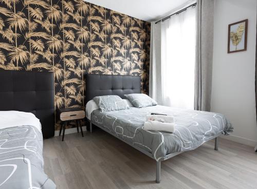 a bedroom with a bed with a black and gold wallpaper at Hotel Europe BLV in Paris