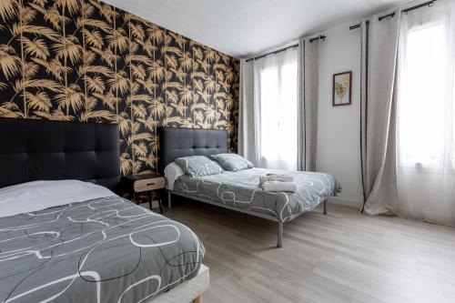 a bedroom with two beds and a wall of windows at Hotel Europe BLV in Paris