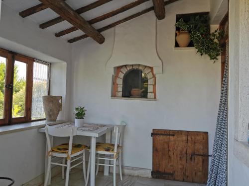cocina con mesa y sillas en una habitación en Casale Fonte delle Pietre, en Offida