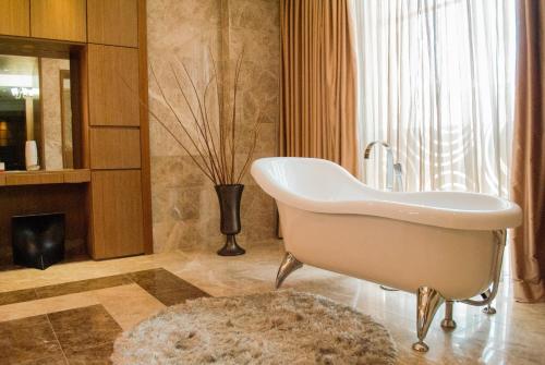 ein Badezimmer mit einer Badewanne und einer Vase in der Unterkunft Hesperia WTC Valencia in Valencia