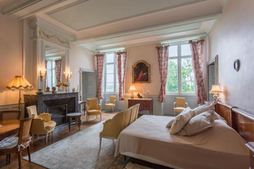 1 dormitorio con 1 cama, mesa y sillas en Chateau d'Estrac, en Hastingues