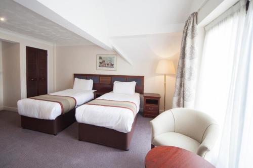 a hotel room with two beds and two lamps at The Holt Hotel in Steeple Aston