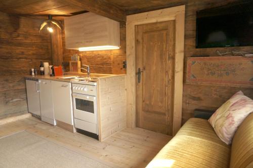a kitchen with a stove and a sink in a cabin at Wölzenberg Alm in Reith im Alpbachtal