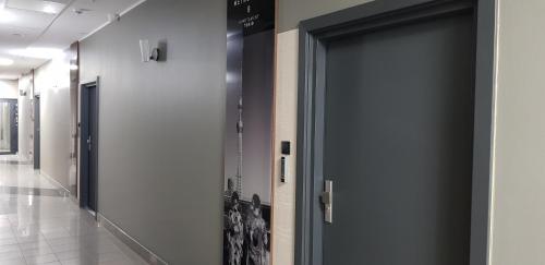 a hallway with a door in a building at Metropolis Apartamenty Centrum in Kalisz