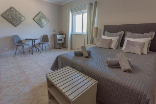 a bedroom with a bed and a table and chairs at Casa da Falfeira B&B in Lagos