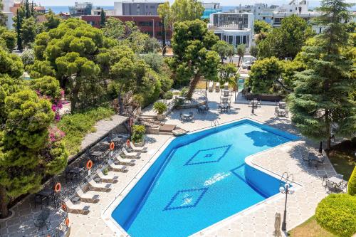 an overhead view of a pool with chairs and trees at Oasis Hotel Apartments in Athens