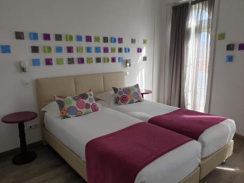 a bedroom with two beds with purple sheets at Thomar Story - Guest House in Tomar
