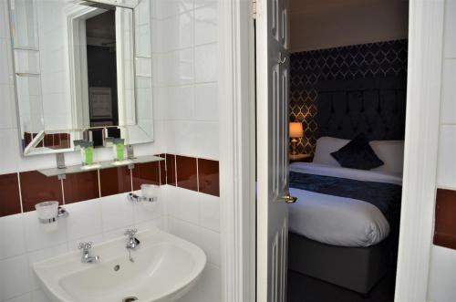a bathroom with a sink and a bed at Hotel St George by Nina in Dublin